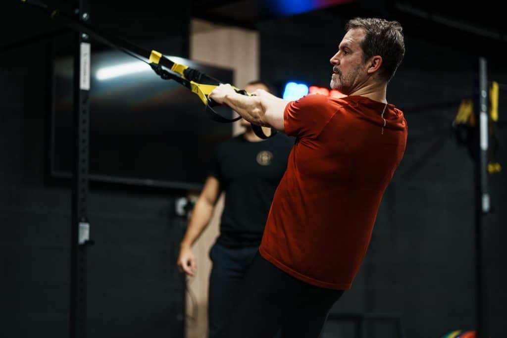 Client en séance de TRX encadré par un coach chez Ultimate Physical, alternative à la salle de sport Bordeaux en libre accès