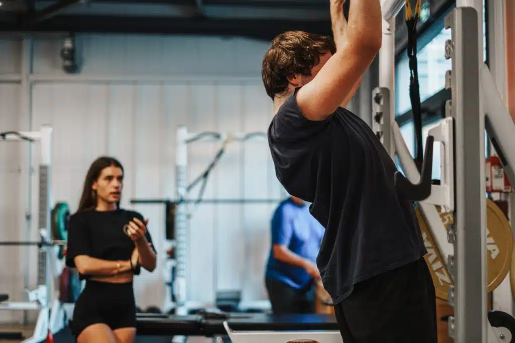 Le coaching à Mérignac 4 Adhérent d'Ultimate Mérignac en séance de traction, sous le regard de sa coach