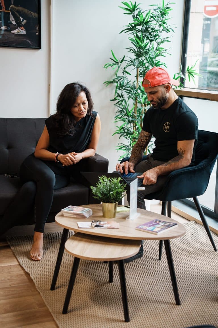 Ultimate | Le Spécialiste de l'accompagnement avec Coach sportif | Bordeaux & Mérignac 4 Bilan personnalisé Ultimate : un coach et une membre échangent sur ses objectifs dans l’espace d’accueil du centre